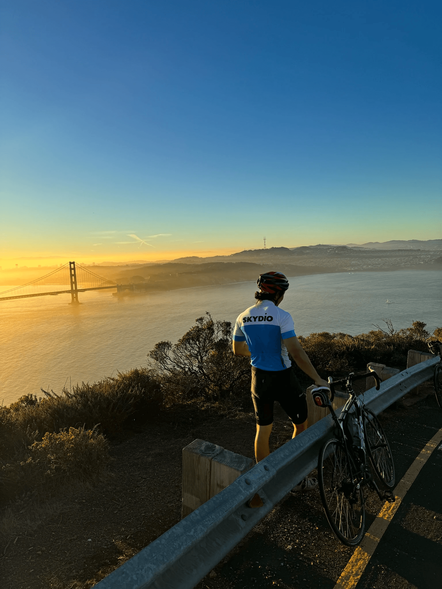 Dennis standing with a bike at Hawk Hill during sunset